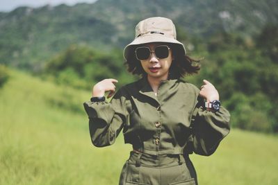 Young woman wearing sunglasses standing on field