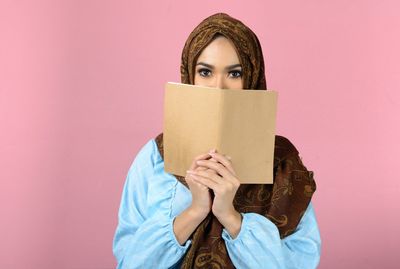 Portrait of a young woman holding book
