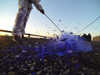 Low section of man hitting golf ball on shore