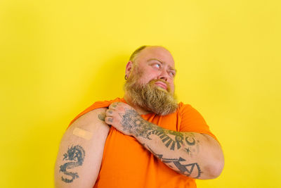 Portrait of man wearing mask against yellow background