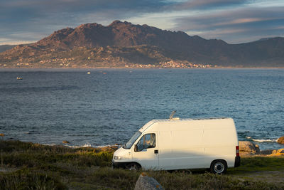 Scenic view of sea by mountains against sky