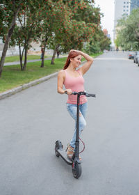 Rear view of young woman standing on road