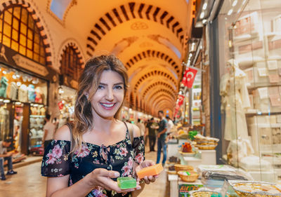 Portrait of smiling woman standing at mall