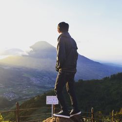 Full length of man looking at mountains against sky