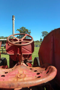 Close-up of machine part on field against clear sky