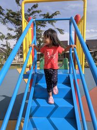 Full length of girl playing on slide at playground