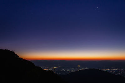 Scenic view of silhouette mountains against sky at night