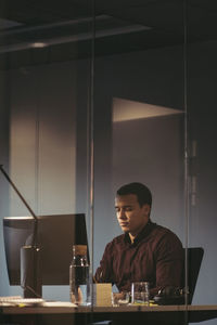 Tired businessman working at desk in dark office