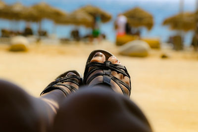 Low section of woman wearing sandals at beach