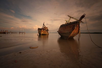 Ship in sea against sky during sunset