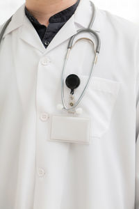 Midsection of woman with stethoscope against white background