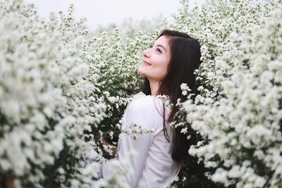 Beautiful woman standing by flowering plants