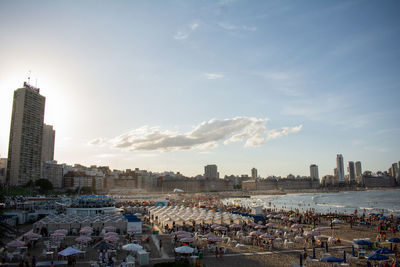 Panoramic view of crowd and buildings in city against sky