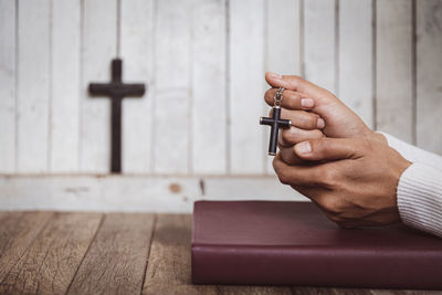 Cropped hands of woman using mobile phone on table