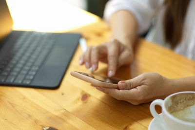 Midsection of woman using laptop on table