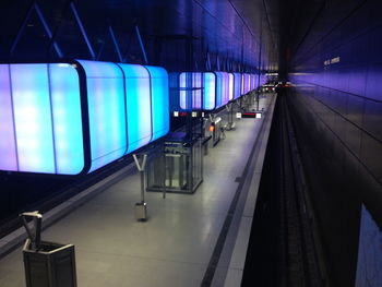 Illuminated railroad station platform at night