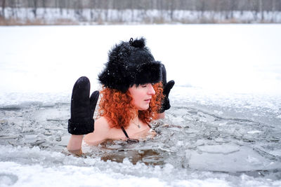 Rear view of woman swimming in snow