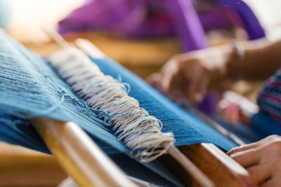 Close-up of woman working on loom