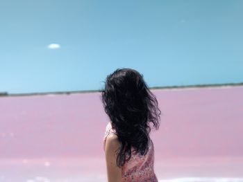 Rear view of woman against pink lake against sky