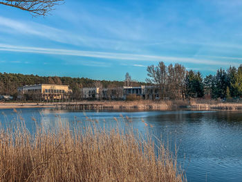 Scenic view of lake by building against sky