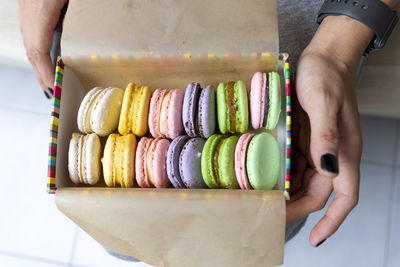 Midsection of woman holding macaroons in box