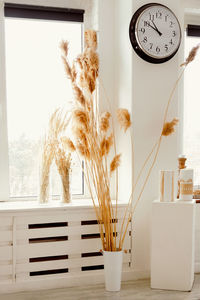 Wheat ears in a glass vase on a wooden table. copy, empty space for text