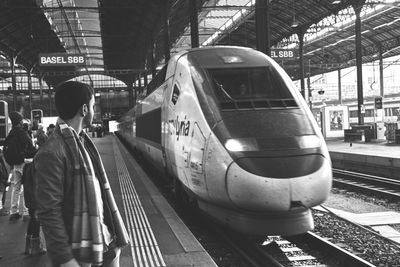 Rear view of woman standing on railroad station platform