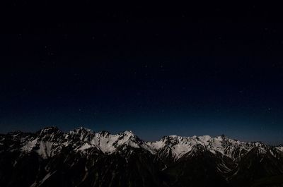 Low angle view of mountains against clear sky at night