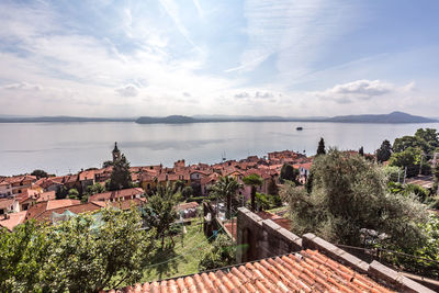 High angle view of townscape by sea against sky