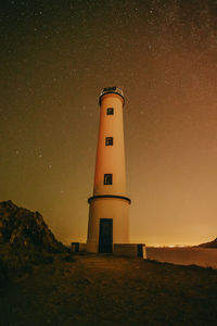 Lighthouse against sky at night