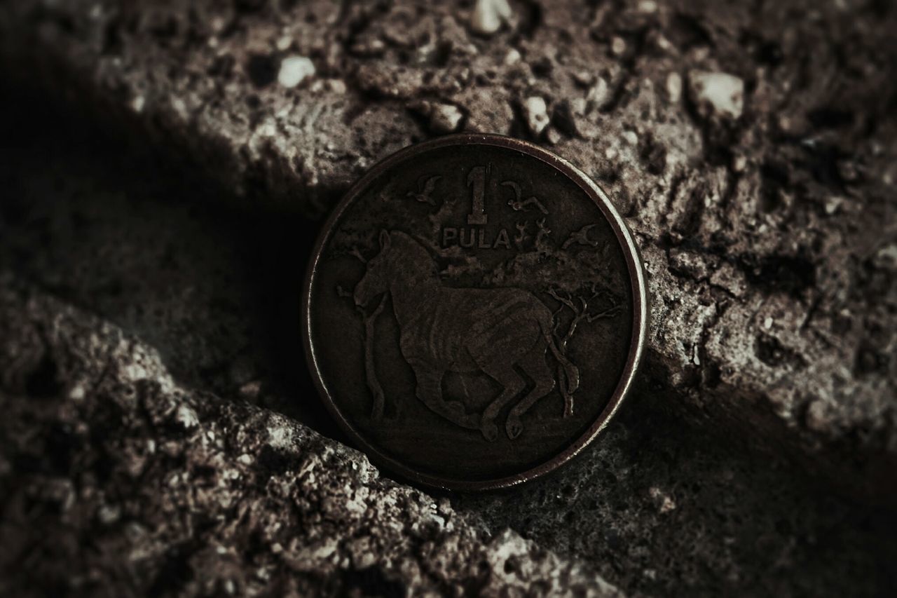 HIGH ANGLE VIEW OF OLD COIN ON METAL