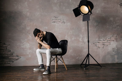 Handsome man sitting on chair at film studio