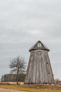 Low angle view of traditional building on field against sky