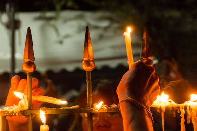 Close-up of lit candles in temple at night