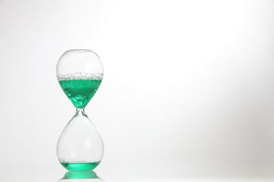 Close-up of hourglass against white background