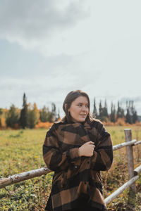 Portrait of woman standing on field against sky