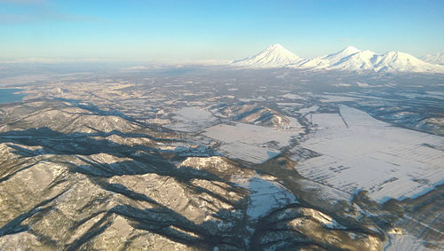 Aerial view of snow covered landscape against sky
