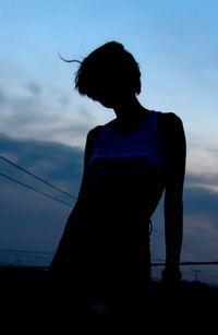 Silhouette woman standing against sky during sunset