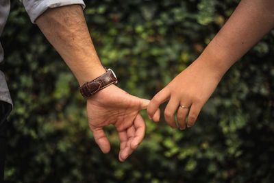 Midsection of couple holding hands