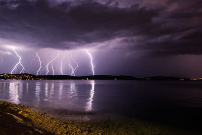 Scenic view of lightning over sea against cloudy sky