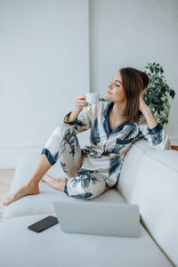 Young woman sitting on sofa at home