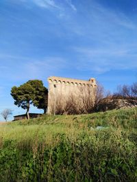 Built structure on field against sky