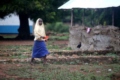 Woman with umbrella walking on field