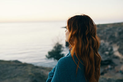 Woman looking at sea against sky