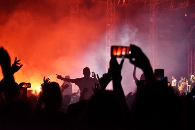 Silhouette people photographing at music concert