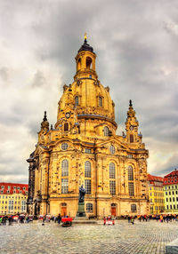 Buildings in city against cloudy sky