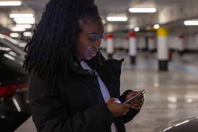 Young woman using mobile phone in city