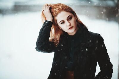 Portrait of young woman standing in snow