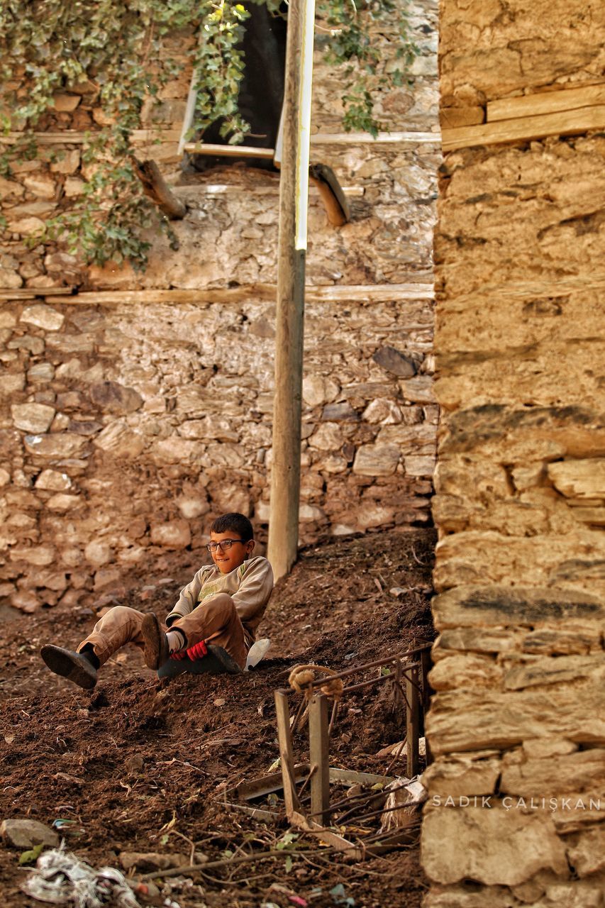 MAN SITTING ON WALL