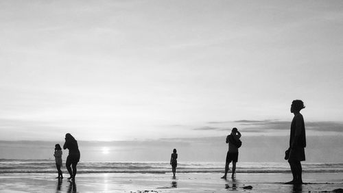 People at beach against sky